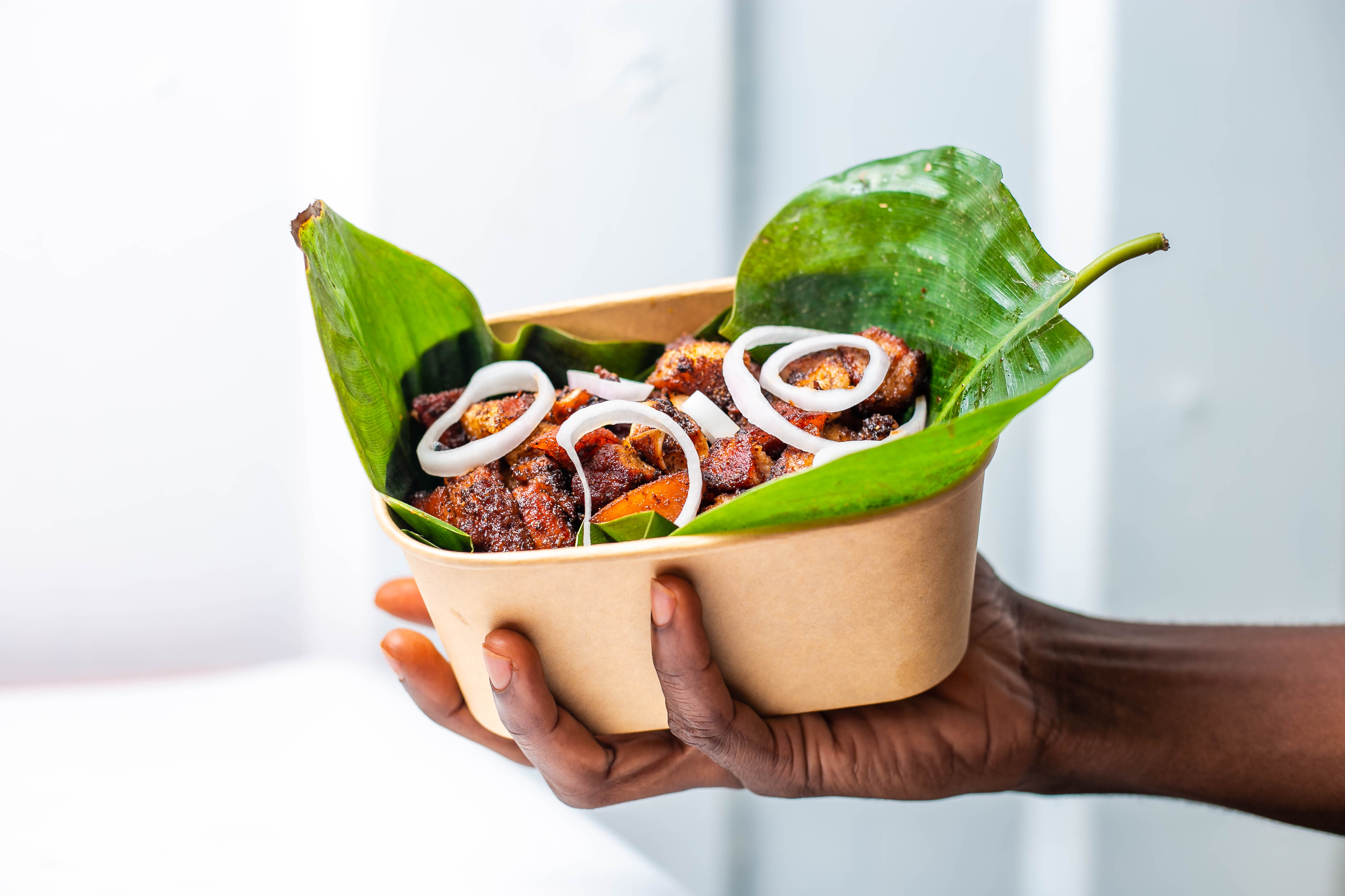 Hand-held bowl of grilled meats